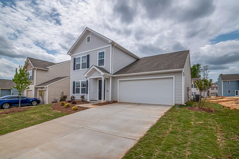 Newly sided two-story home with lap siding, gabled roofline and attached garage